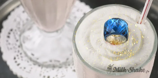 Milk-shake garni de chantilly, de caramel et de copeaux dorés dans un verre haut