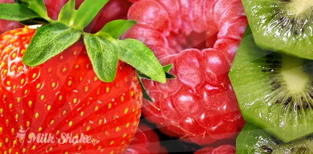 Fruits d'été (pêches, framboises, myrtilles) posés à côté d'un blender