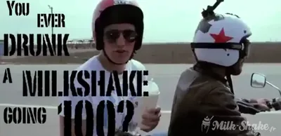 Milk-shake dans un gobelet avec couvercle et paille, tenu à la main