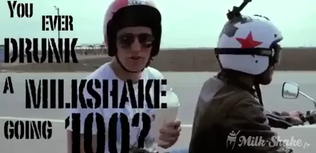 Milk-shake dans un gobelet avec couvercle et paille, tenu à la main